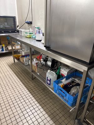 une cuisine équipée d'un plan de travail en inox et d'un réfrigérateur
