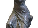 statue of a woman sitting on a bench with her hands clasped
