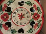 a clock that has been painted with flowers on it