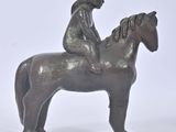une statue représentant une femme à cheval sur fond blanc