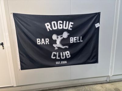 une enseigne portant l'inscription « Rogue Bar and Bell Club » accrochée au mur