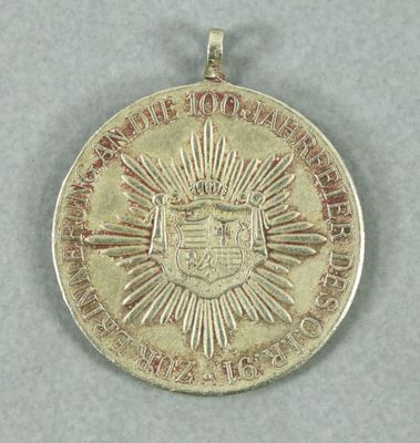 an image of a gold medal with a sunburst on it