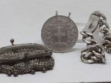 a silver purse and a silver coin on a table