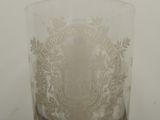 un verre orné d'un blason, posé sur une table