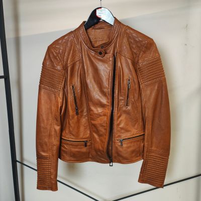 une veste en cuir marron suspendue à un porte-manteau dans une pièce