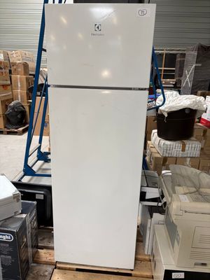 a refrigerator that is sitting in a warehouse with boxes