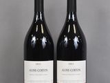two bottles of wine sitting on top of a table next to each other