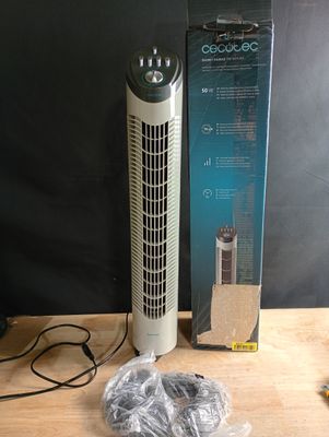 une boîte contenant un purificateur d'air posée sur une table à côté d'une boîte de câbles
