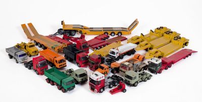 beaucoup de petits camions jouets posés sur une surface blanche