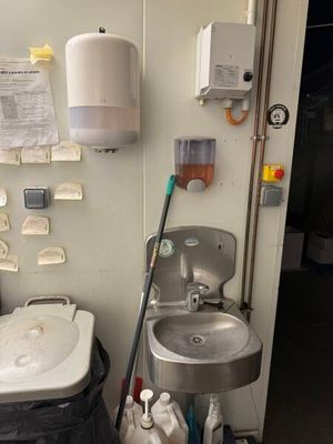 une salle de bains équipée d'un lavabo et d'une poubelle