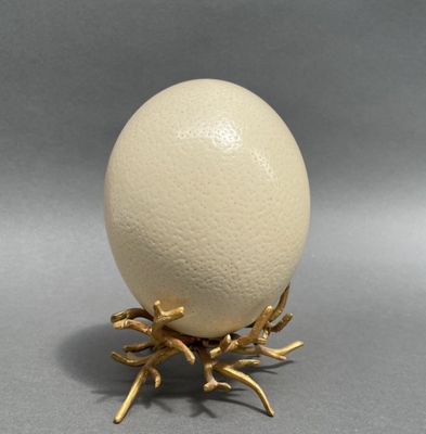 an image of a white egg on a gold stand
