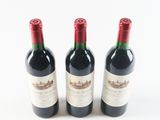 three bottles of red wine sitting next to each other on a white surface