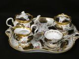 a tray with a tea set on it on a black background