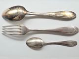 three spoons and a fork on a white surface