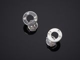 une paire de boucles d'oreilles en argent et diamants posées sur une surface noire