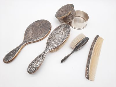 trois brosses, un peigne et une brosse posés sur une surface blanche