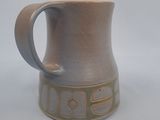 une tasse marron munie d'une anse