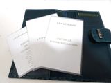 a black wallet with three cards and a pen on it