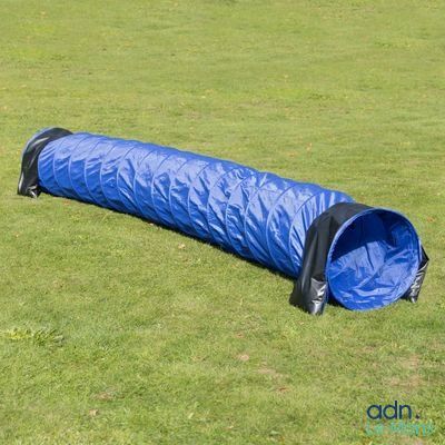 un tunnel bleu et noir dans l'herbe, au sol