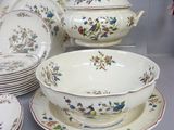 many plates and bowls on a table with a blue background