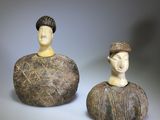 two figurines of a man and a woman sitting next to each other