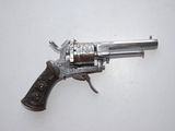 an old silver revolver with a wooden handle on a white surface
