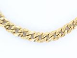 un collier à chaîne en or sur fond blanc