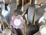 many spoons and spoon spoons in a vase with a pink flower