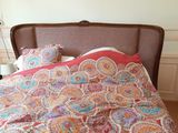 a bed with a colorful comforter and pillows on it