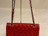 a red purse with a chain hanging from the handle