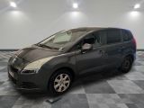 the grey van is parked on a checkered floor in a garage