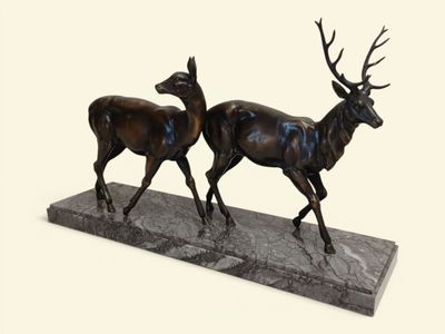 statue représentant un couple de cerfs sur un socle en marbre, sur fond blanc