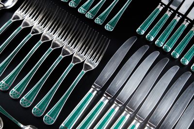 beaucoup de fourchettes et de cuillères en argent et vertes sur la table