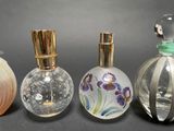 three glass perfume bottles are lined up on a black surface