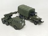 un camion miniature et un autre camion miniature posés sur une surface blanche
