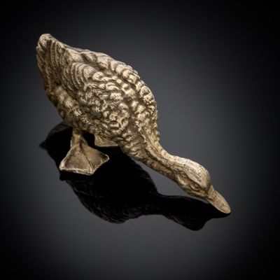 une image représentant une figurine en bronze représentant un canard sur un fond noir