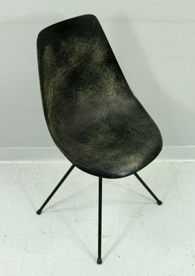 une image représentant une chaise noire dans une pièce blanche