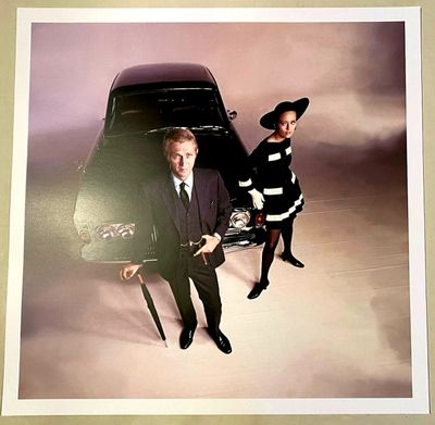 two men in suits standing next to a car