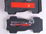 un stylo rouge dans un étui noir posé sur une surface blanche