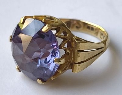 une image représentant une bague en or sertie d'une pierre violette
