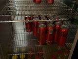 many cans of soda in the refrigerator on the shelf