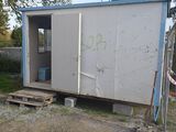 a man that is standing outside of a small building