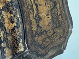 a black and gold decorated box hanging on the wall