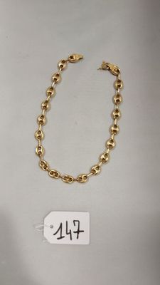 gros plan d'un bracelet en chaîne en or avec une étiquette de prix