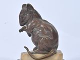 statue of a rat on a marble base on a white background