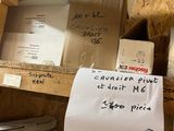 une pile de cartons posée sur une étagère, sur laquelle est accrochée une pancarte