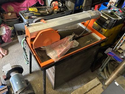 un homme qui travaille sur une machine dans le garage
