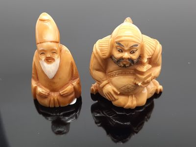 deux figurines représentant un homme et une femme assis sur une surface noire