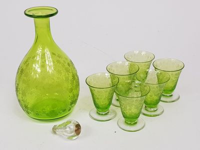 a lot of glasses and a green bottle on the table