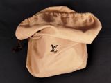 a louis vu bag on a black surface